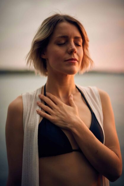 Woman practicing a breathing exercise with her hand on her lung area.