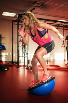 A woman practicing yoga and fitness in a gym after using breathing techniques for fitness.