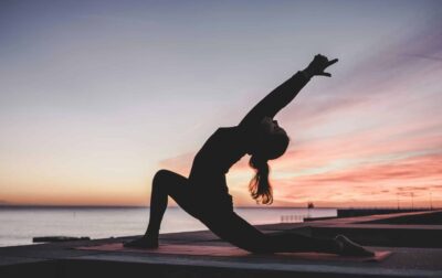 Woman practicing Ujjayi Pranayama on the beach, embracing the ocean breath technique.