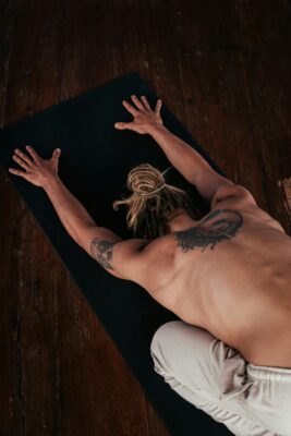 Man practicing Restorative Yoga in Child’s Pose on a yoga mat.