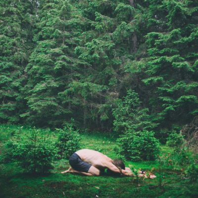 Man practicing Yin Yoga outdoors in a peaceful nature setting.